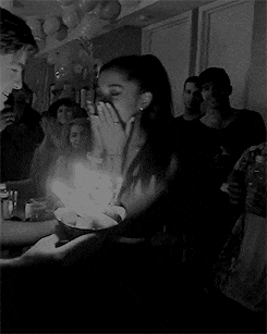 a woman is blowing out a candle on a birthday cake .