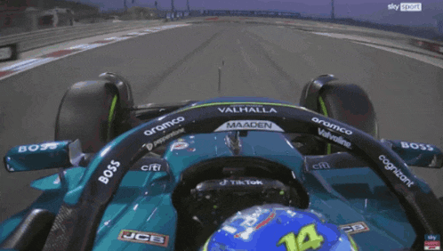 a man in a blue helmet is driving a green racing car