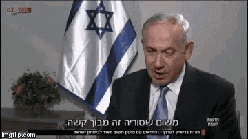 a man in a suit and tie is speaking in front of a flag with a star on it