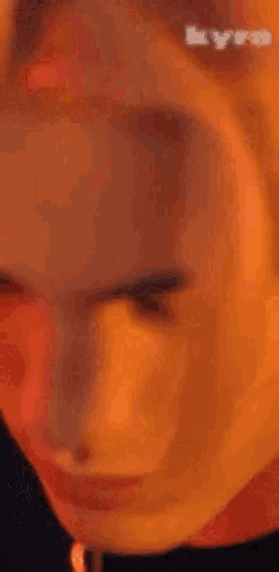 a close up of a person 's face with a necklace around his neck .