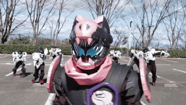 a group of people are standing in a parking lot and one of them is wearing a pig helmet