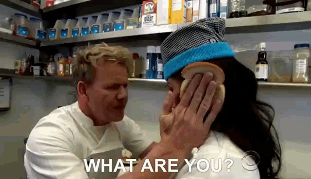 a man putting a piece of bread on a woman 's ear with the words what are you written below him