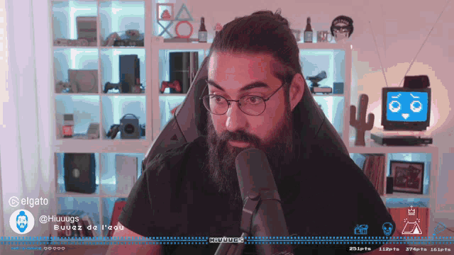 a man wearing glasses and a beard is talking into a microphone