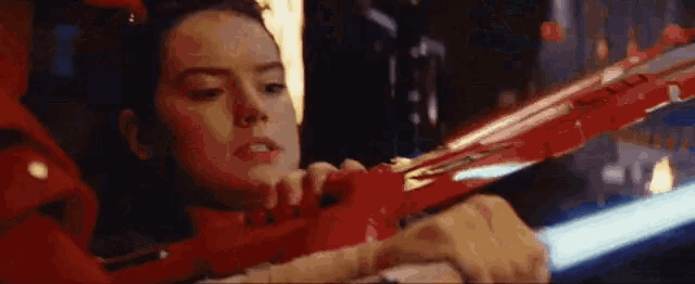 a woman is holding a red toy gun in her hands .