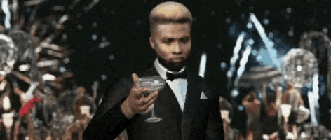 a man in a tuxedo holding a martini glass