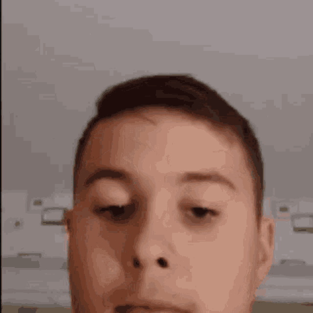 a close up of a man 's face with his eyes closed and a slight smirk on his face .