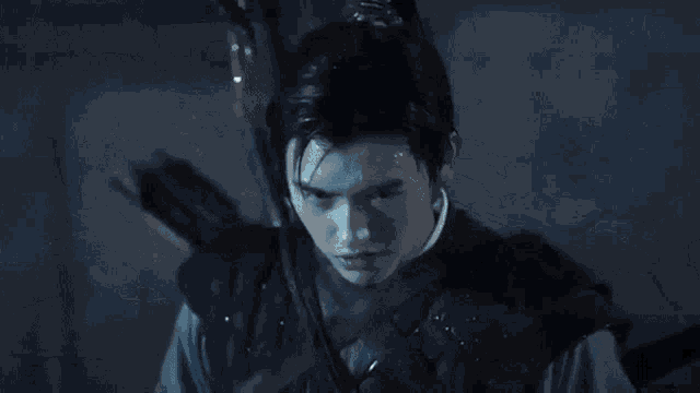 a close up of a person holding a gun in a dark room in a movie .