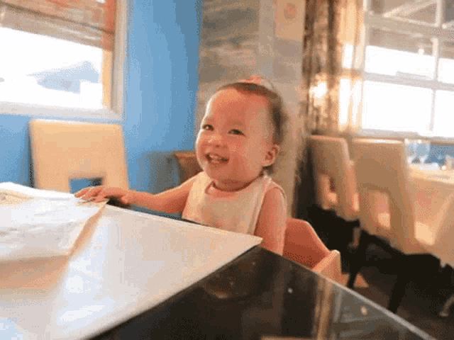 a baby is sitting at a table in a restaurant