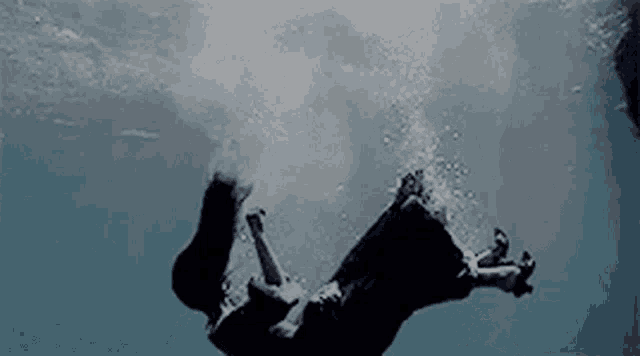 a woman in a dress is falling into the ocean .