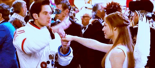 a man and a woman are dancing in a crowd at a party .