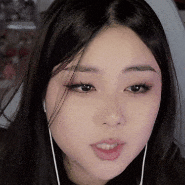 a close up of a woman 's face wearing earbuds