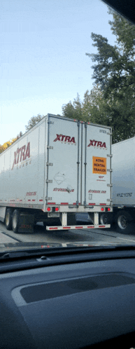 a white xtra trailer is parked next to a white trailer