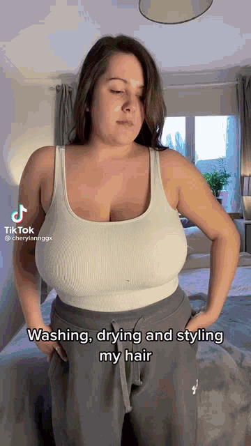 a woman with very large breasts is standing in a room .