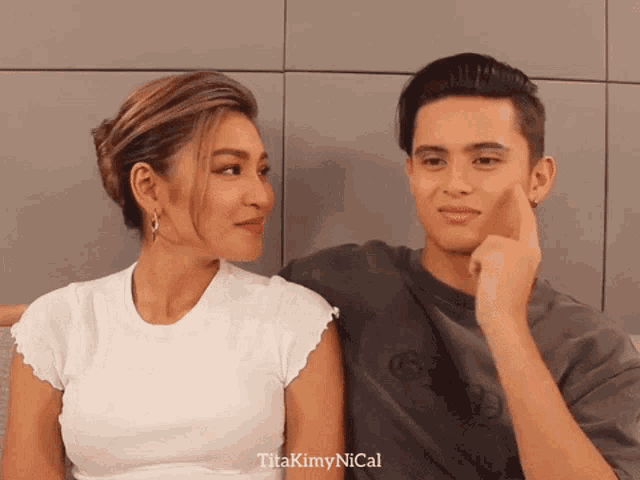 a man and a woman are looking at each other and titakimynical is written in the corner