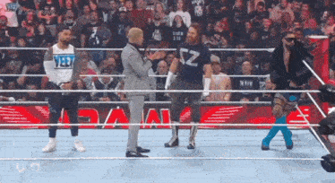 a group of wrestlers are standing in a wrestling ring and one of them has the letter z on his shirt