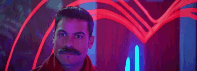 two men dressed as gondoliers are standing next to each other in front of a neon light .