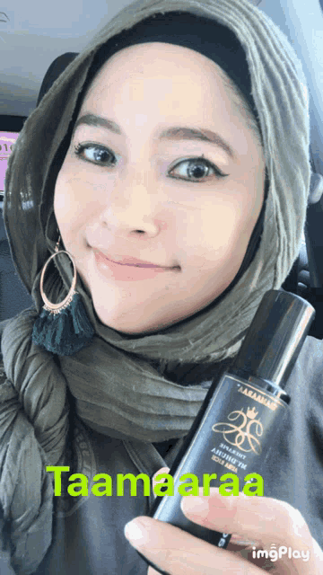 a woman in a hijab is holding a bottle that says taamaaraa