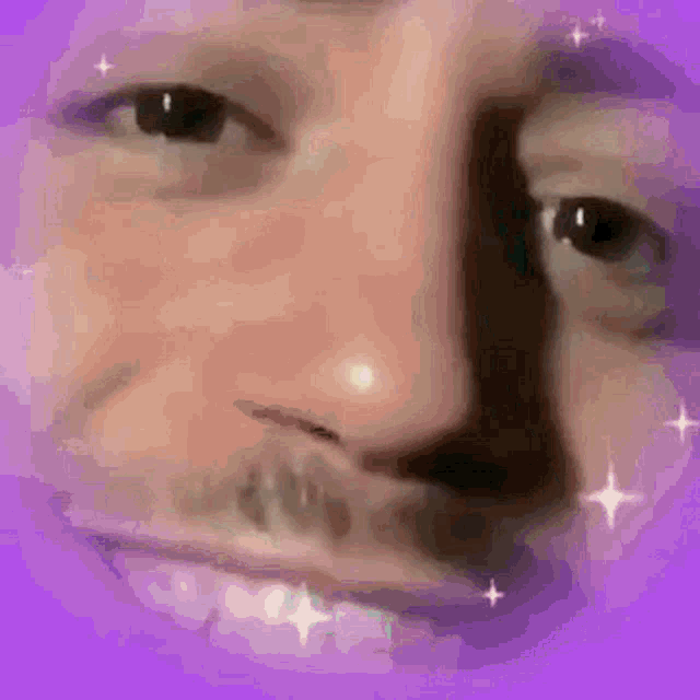 a close up of a man 's face with a purple background and sparkles .