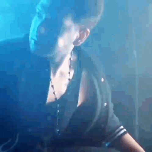 a close up of a person 's face in a dark room with a blue background