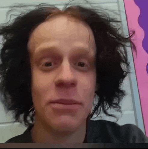 a close up of a man 's face with a pink background