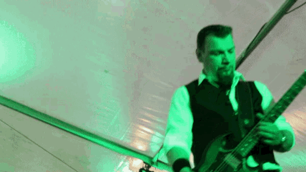 a man with a beard is playing a guitar in a green light