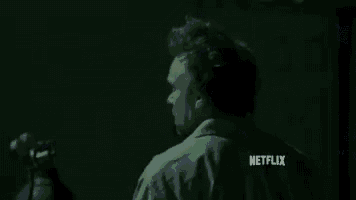 a man is standing in the dark in front of a building in a netflix trailer .