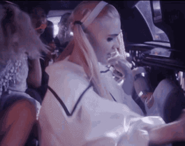 a woman with blonde hair is sitting in a car