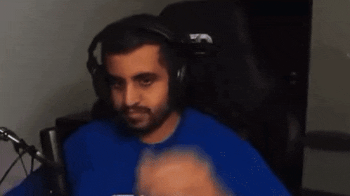 a man in a blue shirt is wearing headphones and a microphone