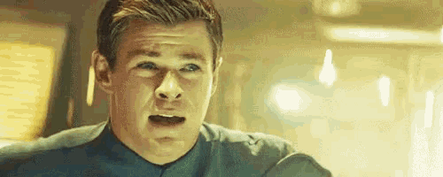 a man is making a funny face with his mouth open in a room .