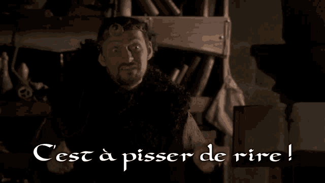 a man with a beard is standing in front of a sign that says cest a pisser de rire