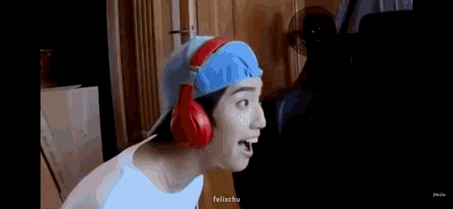 a man wearing headphones and a blue hat is looking at something .
