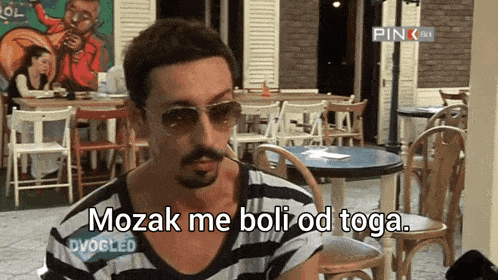 a man wearing sunglasses says mozak me boli od toga in a restaurant