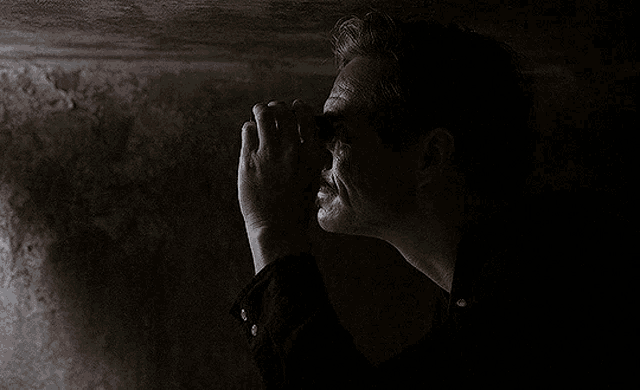 a man in a dark room is holding a flashlight in his hand