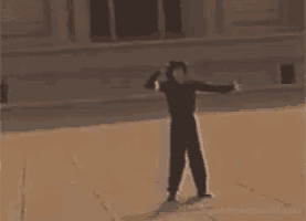 a person with their arms outstretched is standing in front of a building with the word markers on the bottom