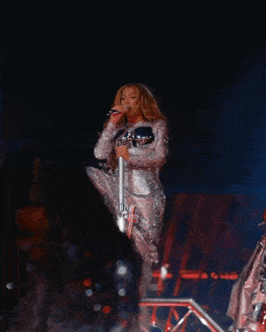 a woman in a sequined dress is dancing on stage