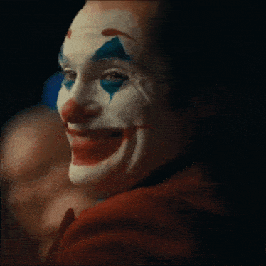 a close up of a clown 's face with his mouth open