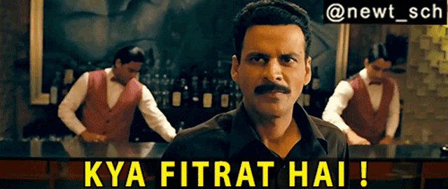 a man with a mustache is standing in front of a bar with the words kya fitrat hai written below him