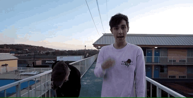a man wearing a pink shirt that says no romance on it