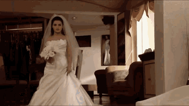 a bride in a wedding dress is walking through a room