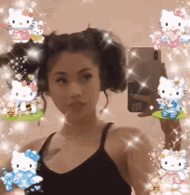 a girl is taking a selfie in front of a mirror with hello kitty characters on her hair .