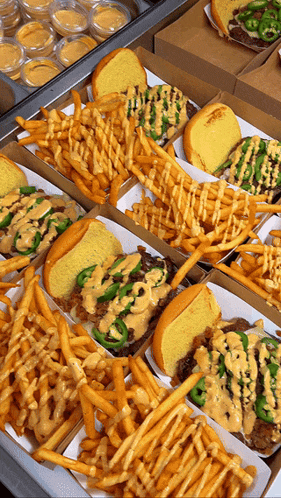 a variety of sandwiches and french fries are displayed on a table