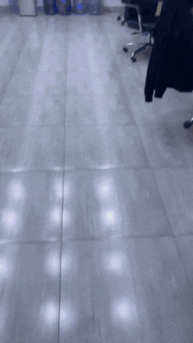 a row of water bottles are lined up on the floor in a room