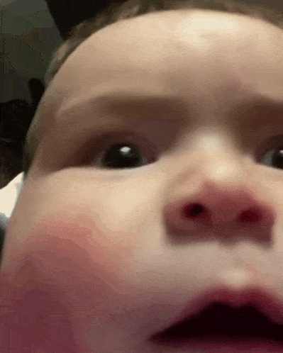 a close up of a baby 's face with a very serious look on his face
