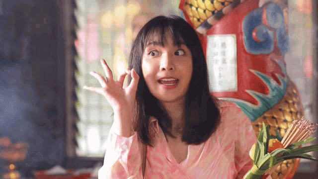 a woman in a pink shirt is making a face