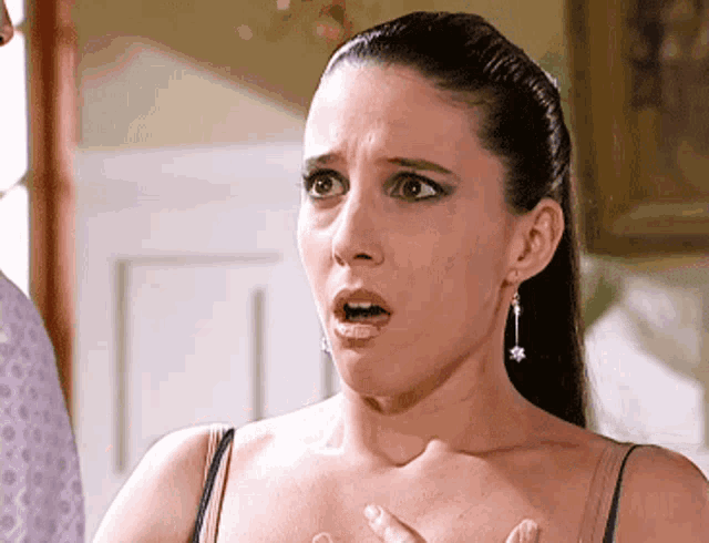 a woman with a surprised look on her face wearing earrings