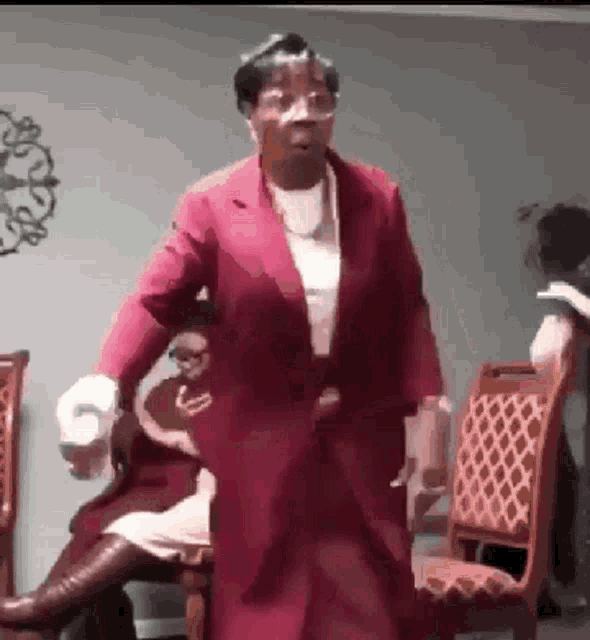 a woman in a red jacket is standing in a room
