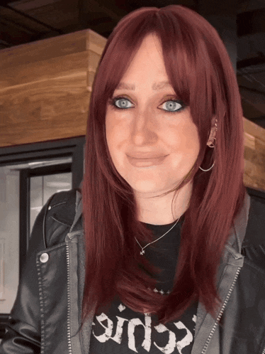 a woman with red hair is wearing a black shirt that says sin