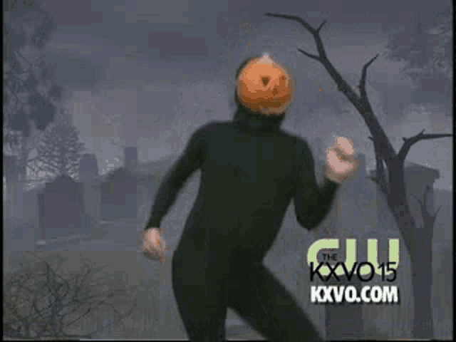 a man in a black suit and pumpkin head is dancing in a cemetery .