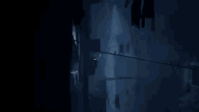 a person is hanging from a rope in a dark room in a game .