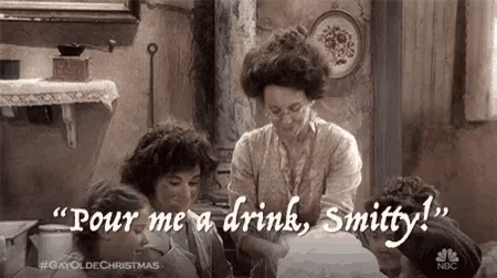 a woman is pouring a drink into a glass while sitting at a table with other people .